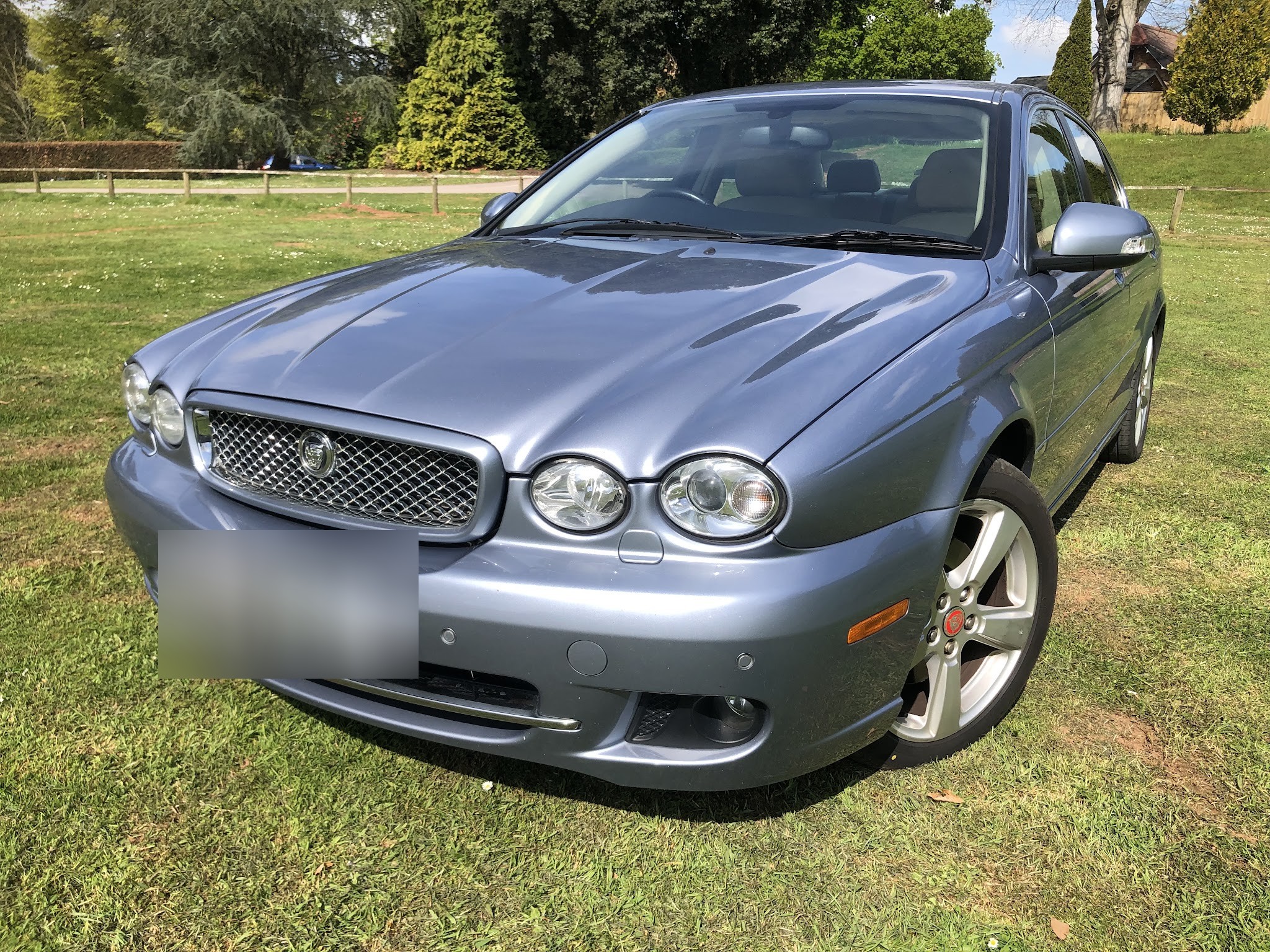 A customer's silver blue Jaguar X-Type on the grass