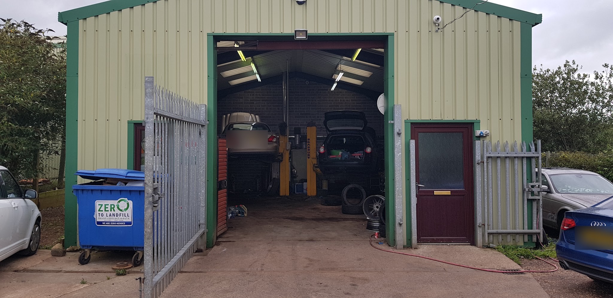 Two lifts inside the LP Autotech workshop, seen from the yard